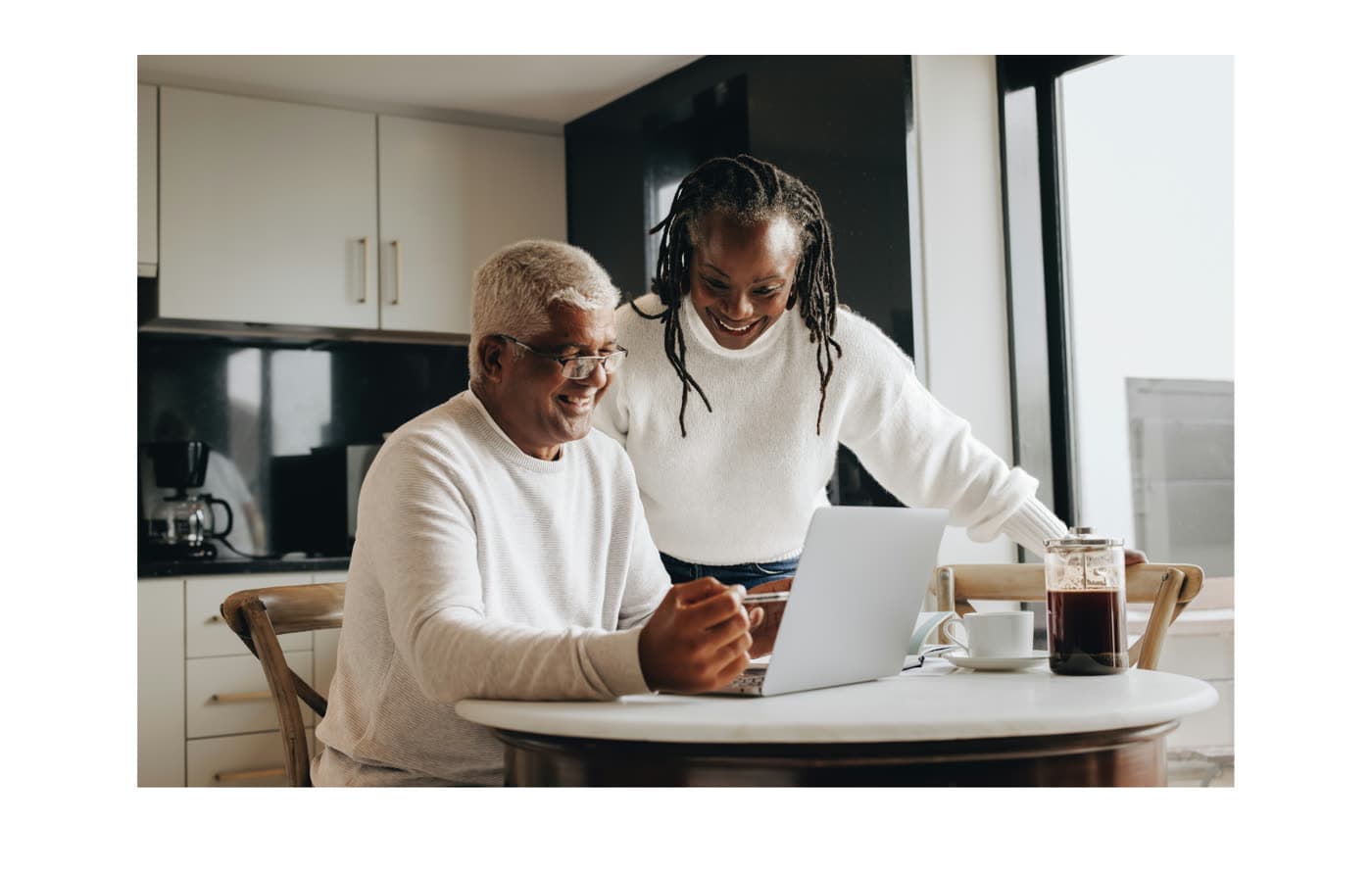 A grandparent and grandchild looking at a daily card on a laptop